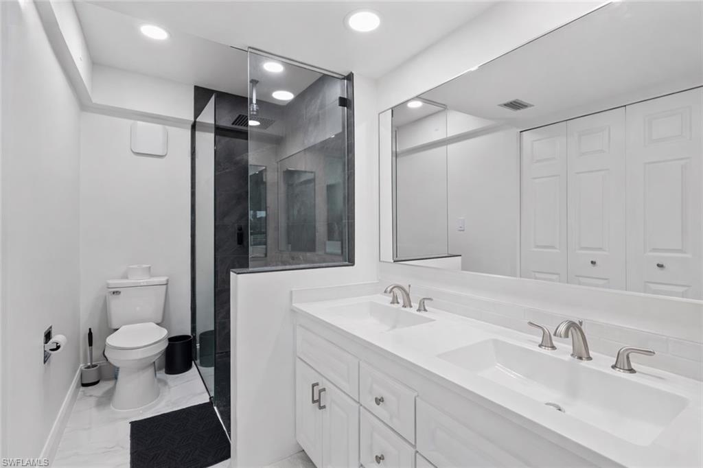 452 Bristle Cone Lane, Unit 27 Naples, FL 34113 - Photo 10 of 16 Full bathroom featuring double vanity, a stall shower, a closet, light marble finish flooring, and recessed lighting