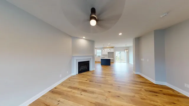 a view of empty room with wooden floor and fireplace