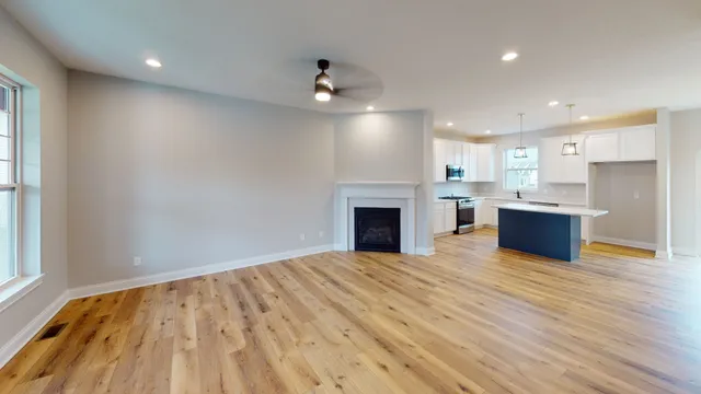 a view of kitchen with kitchen island microwave and wooden floor