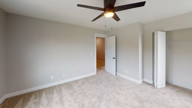 an empty room with a ceiling fan and a window