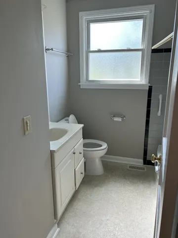 a bathroom with a toilet sink and window