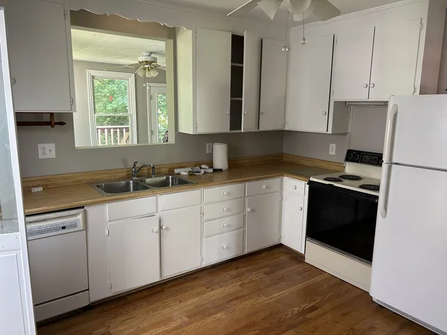 a kitchen with granite countertop white cabinets and black appliances