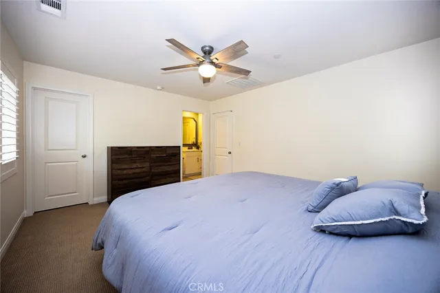 a bedroom with a bed and ceiling fan
