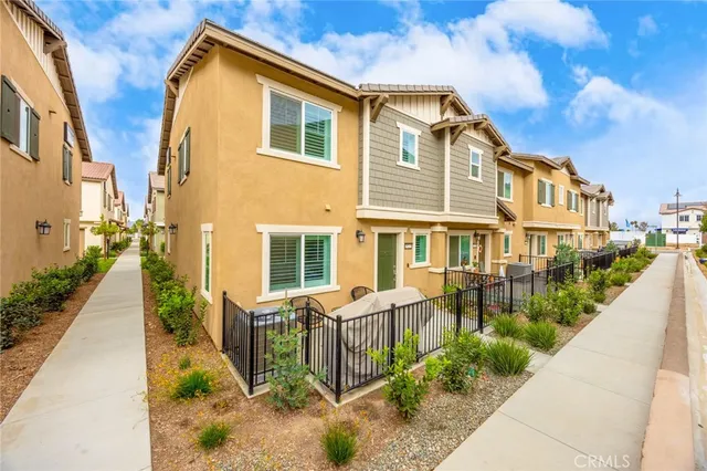 a view of a brick house with many windows next to a yard