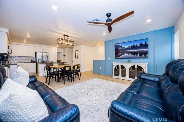 a living room with furniture kitchen area and a fireplace