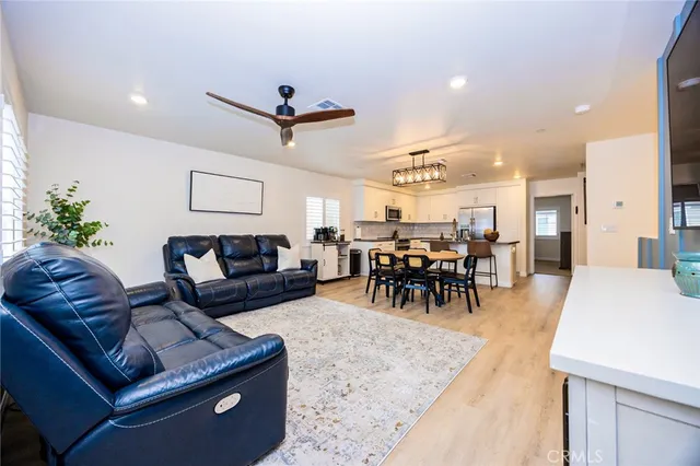 a living room with furniture and a dining table with kitchen view