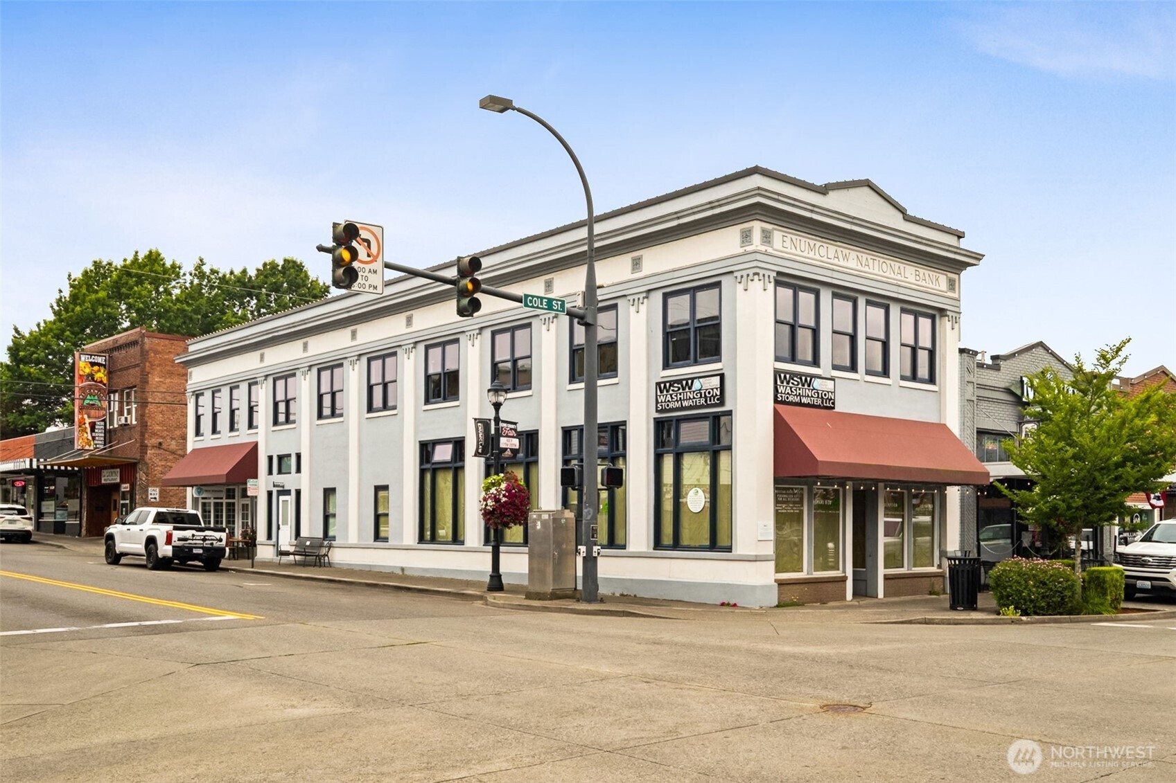 a front view of a building with a garden and plants