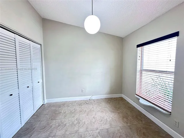 a view of a workspace with a window and dining table in a room