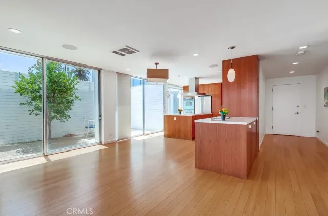 a large kitchen with stainless steel appliances kitchen island granite countertop a refrigerator a oven and a sink with wooden cabinets