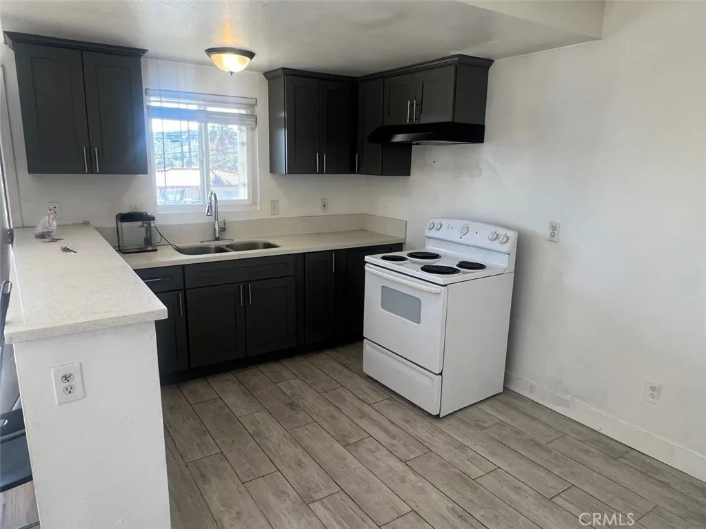 1064 West 48th Street San Bernardino, CA 92415 - Photo 4 of 12 a kitchen with a sink stove top oven and cabinets