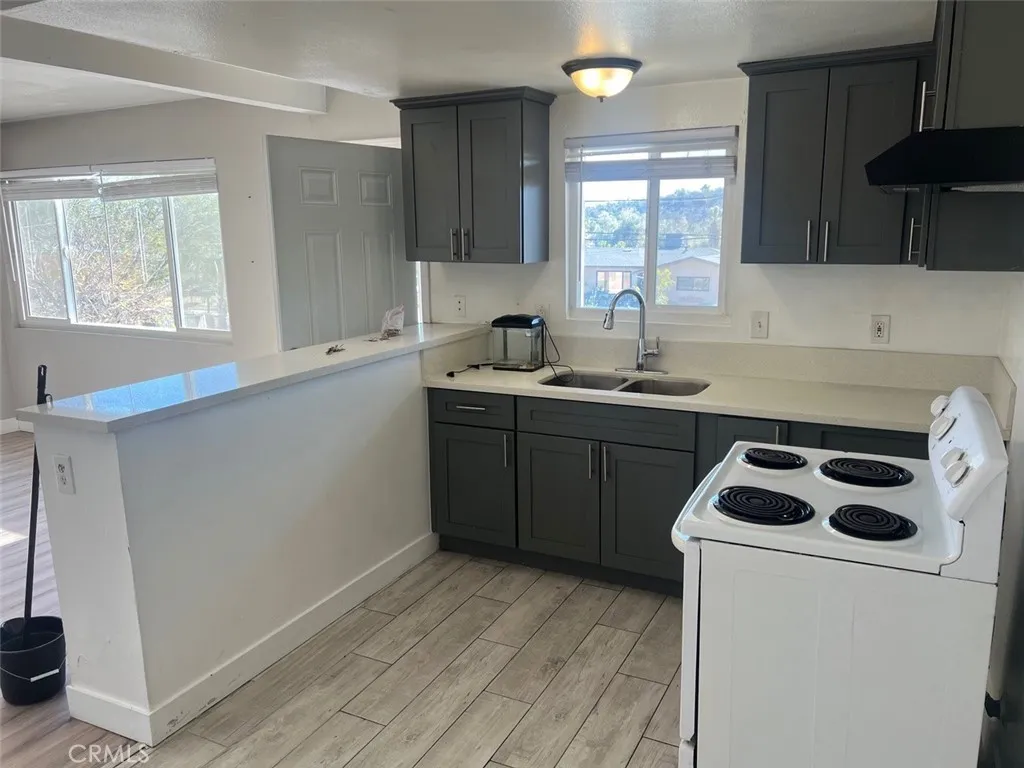 1064 West 48th Street San Bernardino, CA 92415 - Photo 5 of 12 a kitchen with a sink a stove and cabinets