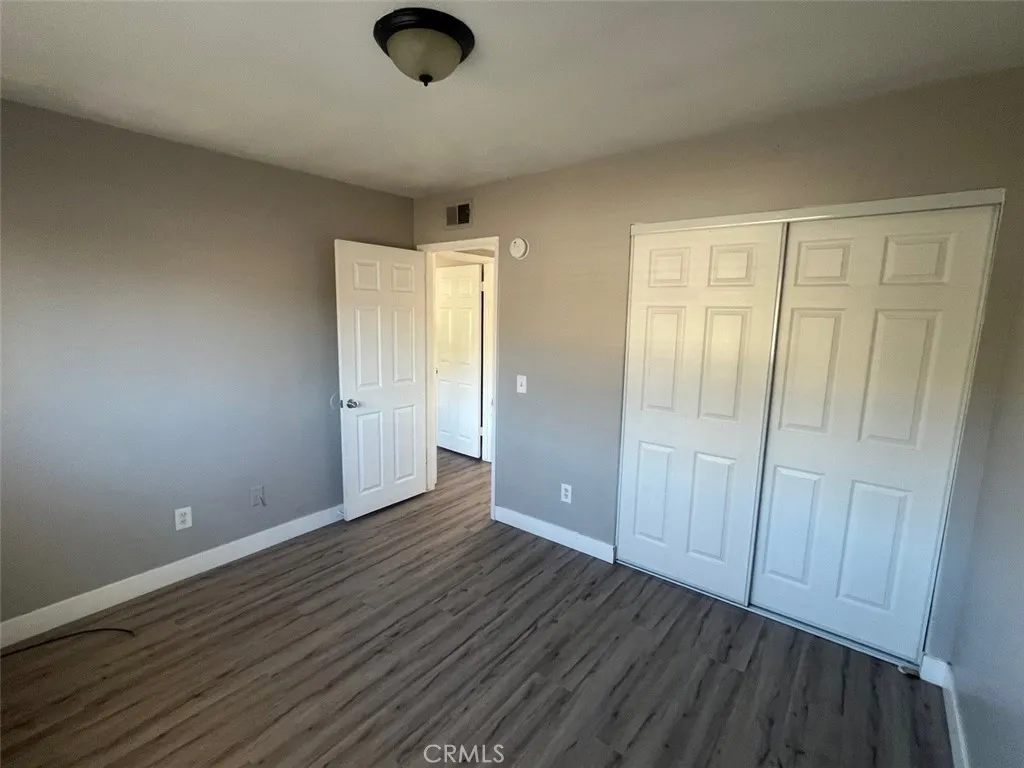1064 West 48th Street San Bernardino, CA 92415 - Photo 8 of 12 an empty room with wooden floor and windows