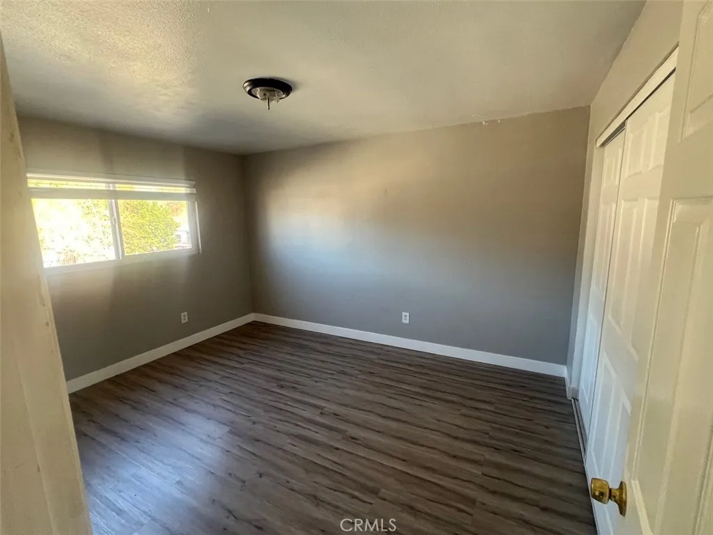 1064 West 48th Street San Bernardino, CA 92415 - Photo 9 of 12 an empty room with wooden floor and windows