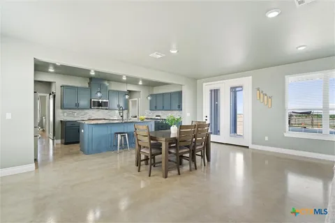 a living room with furniture a dining table and kitchen view