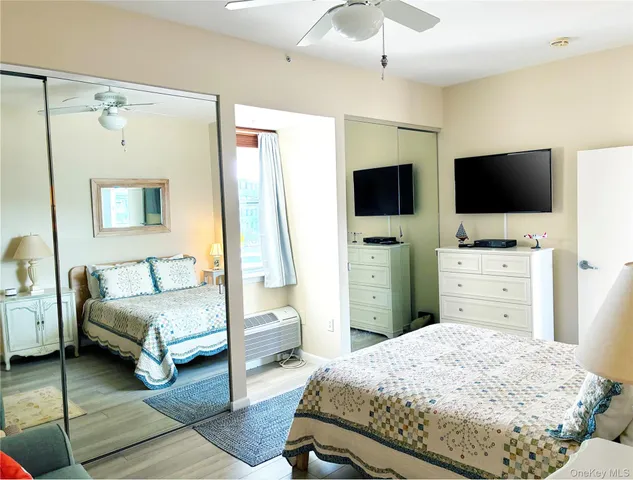 a bedroom with a bed and a flat tv screen on dresser