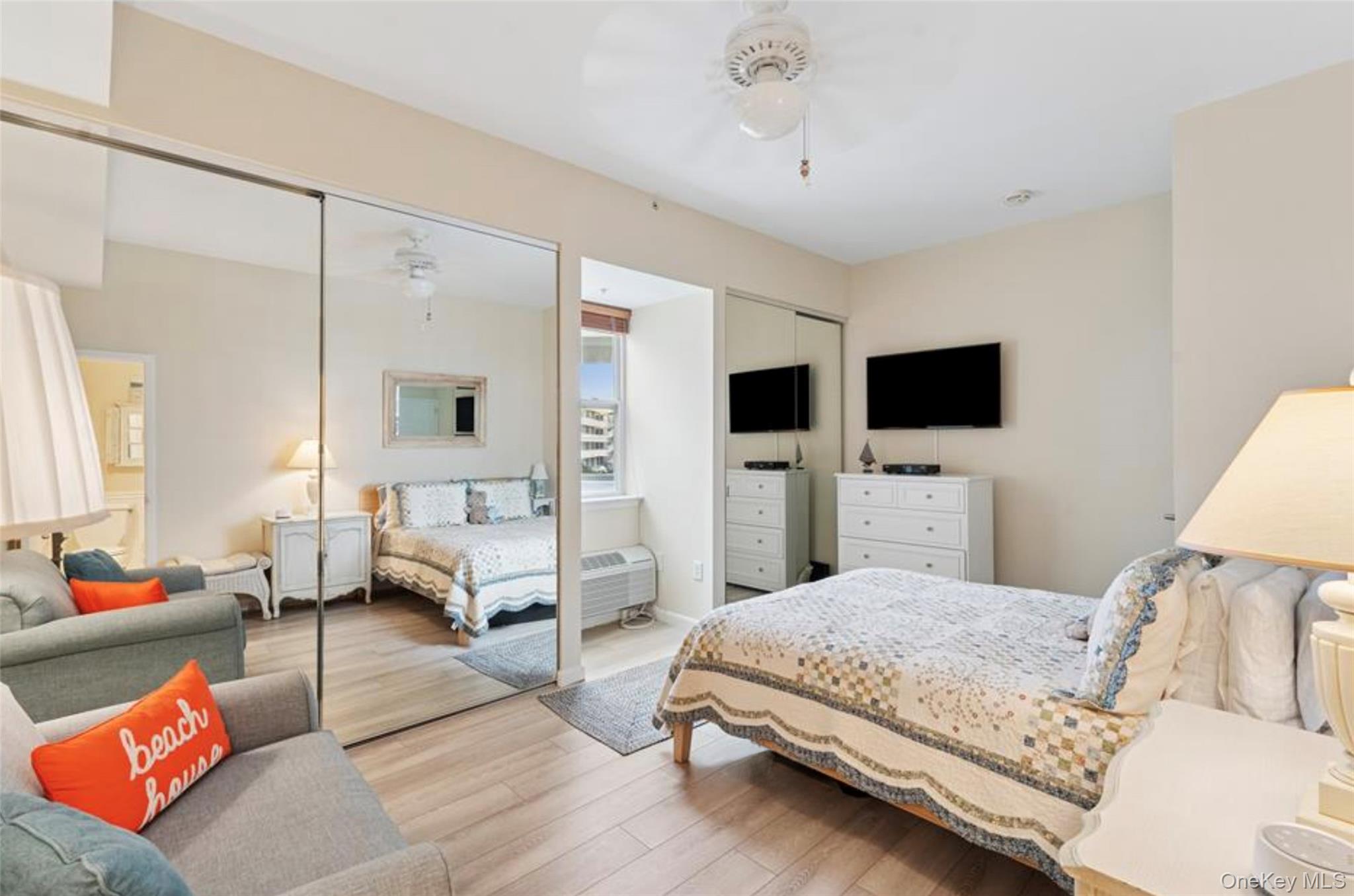 250 Dune Road, Unit 120 Westhampton Beach, NY 11978 - Photo 7 of 11 a bedroom with a bed couch and a flat screen tv