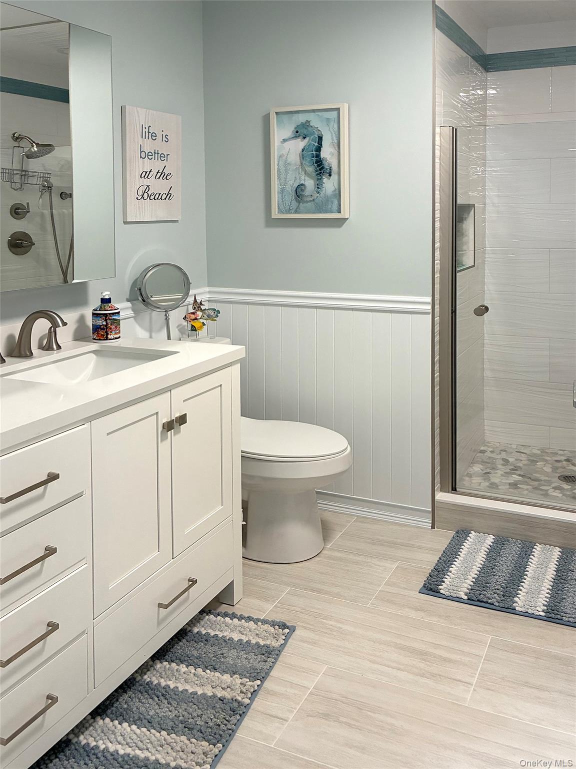 250 Dune Road, Unit 120 Westhampton Beach, NY 11978 - Photo 8 of 11 a bathroom with a toilet sink and mirror