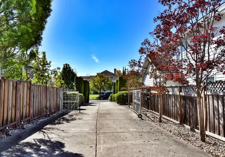 a view of a yard with wooden fence