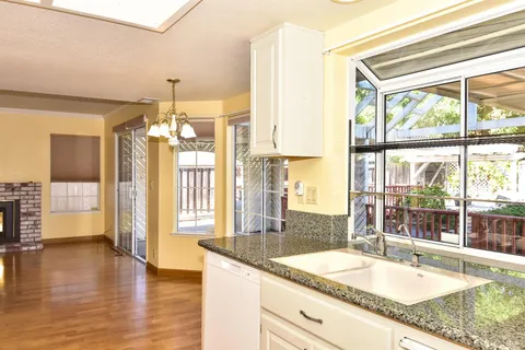 a bathroom with a granite countertop sink and a large mirror