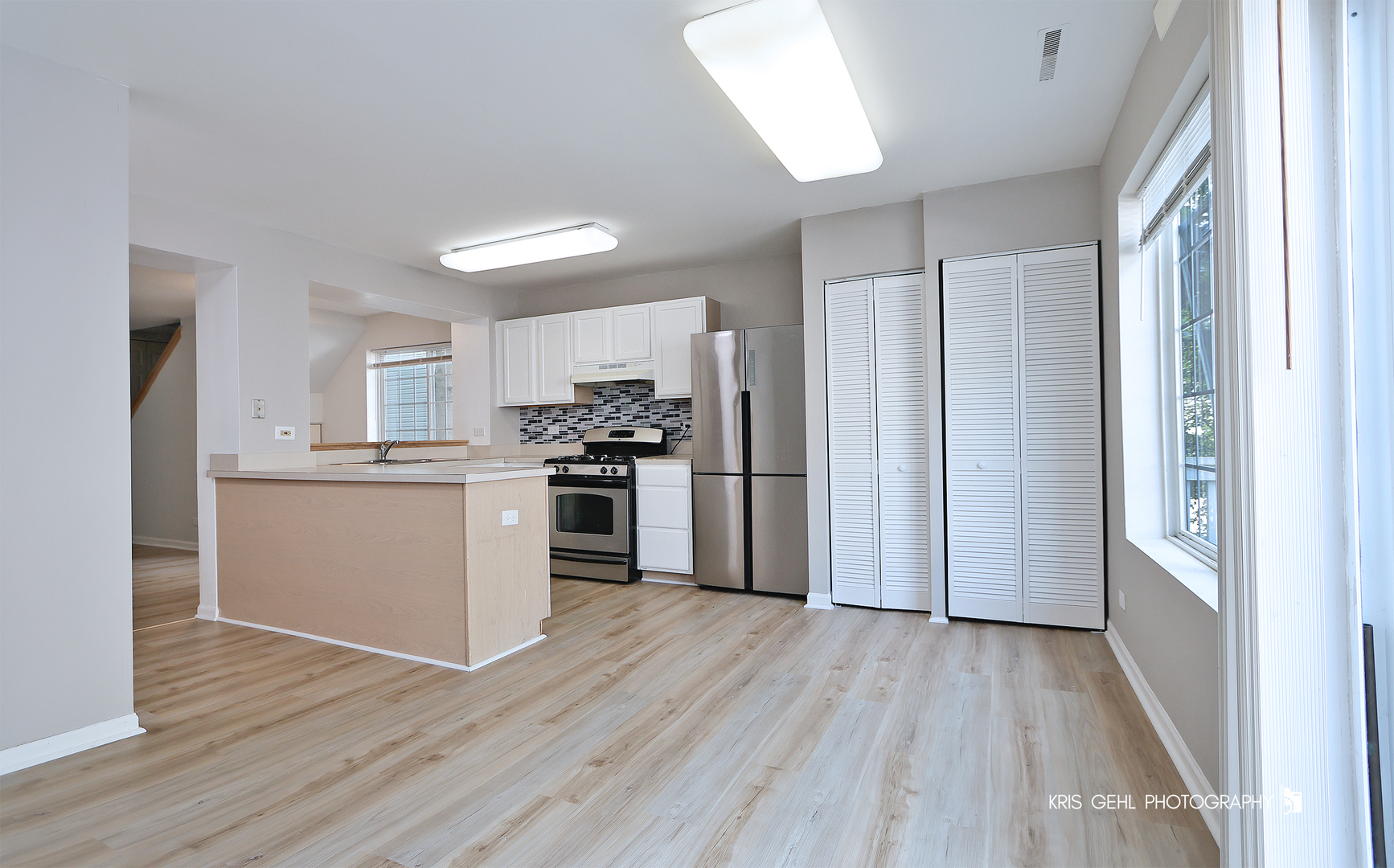 321 West Whispering Oaks Lane, Unit 321 Round Lake, IL 60073 - Photo 8 of 15 a kitchen with a refrigerator a stove top oven and wooden floor