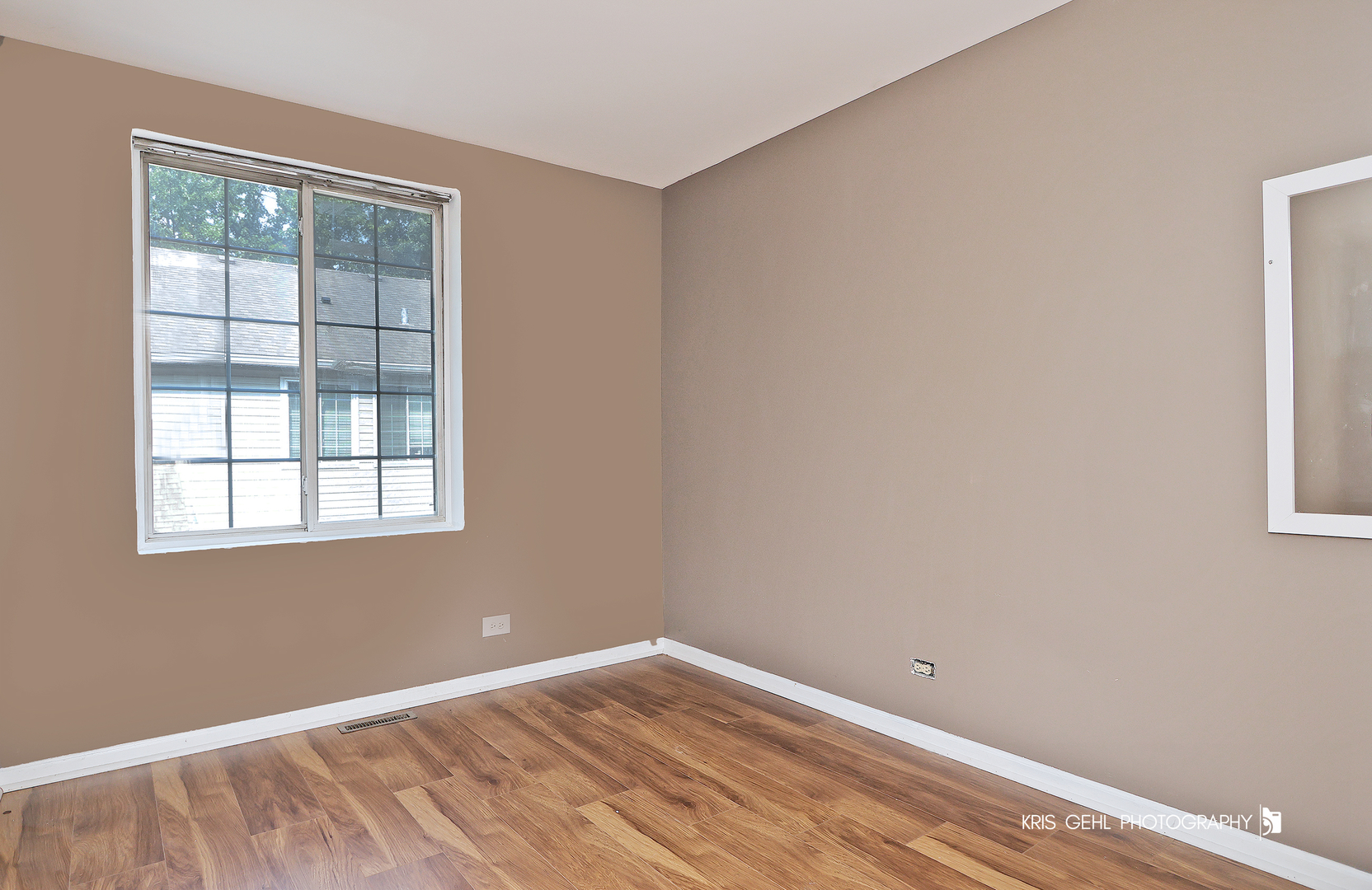 321 West Whispering Oaks Lane, Unit 321 Round Lake, IL 60073 - Photo 14 of 15 a view of an empty room with wooden floor and a window