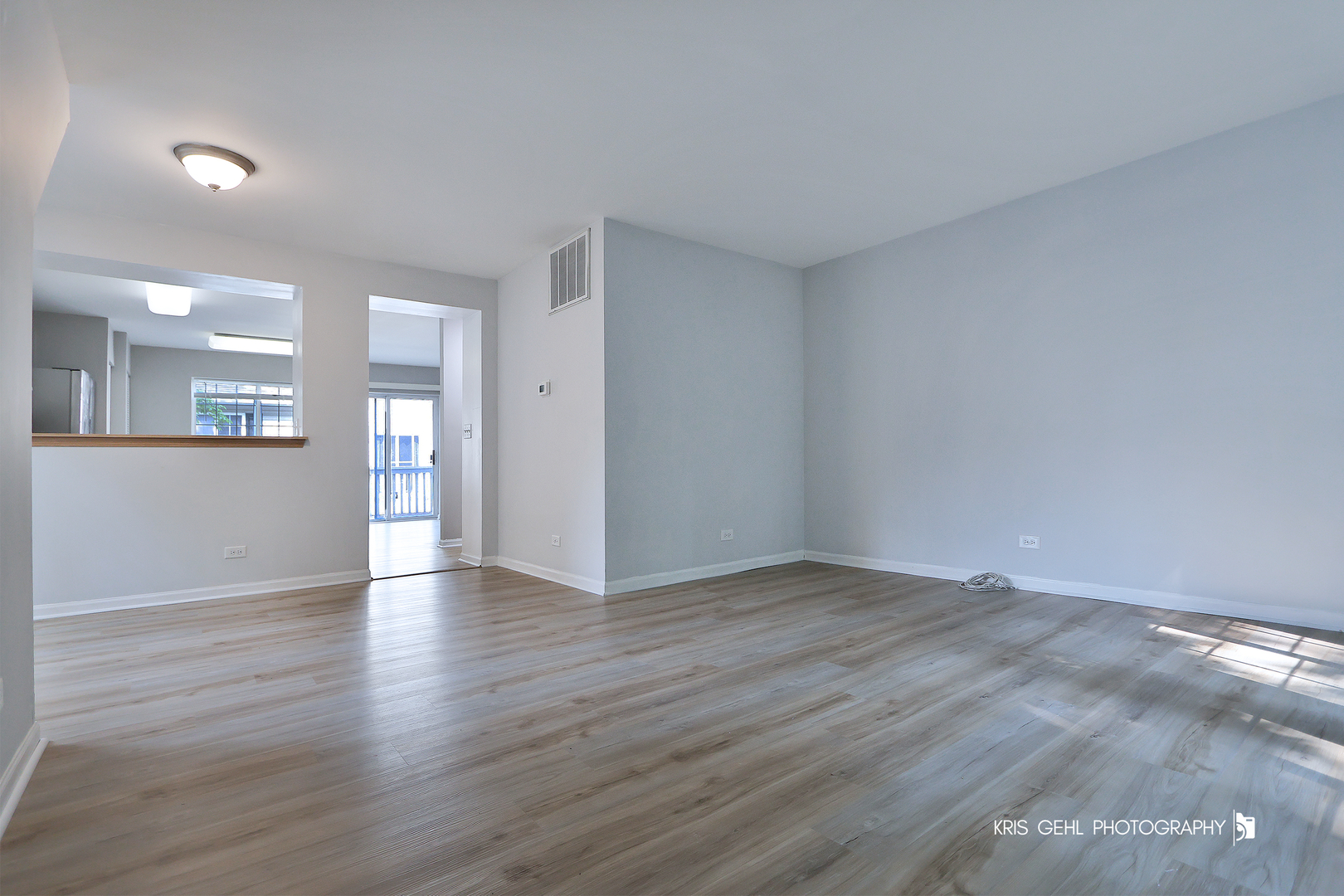 321 West Whispering Oaks Lane, Unit 321 Round Lake, IL 60073 - Photo 4 of 15 a view of an empty room with wooden floor and a window