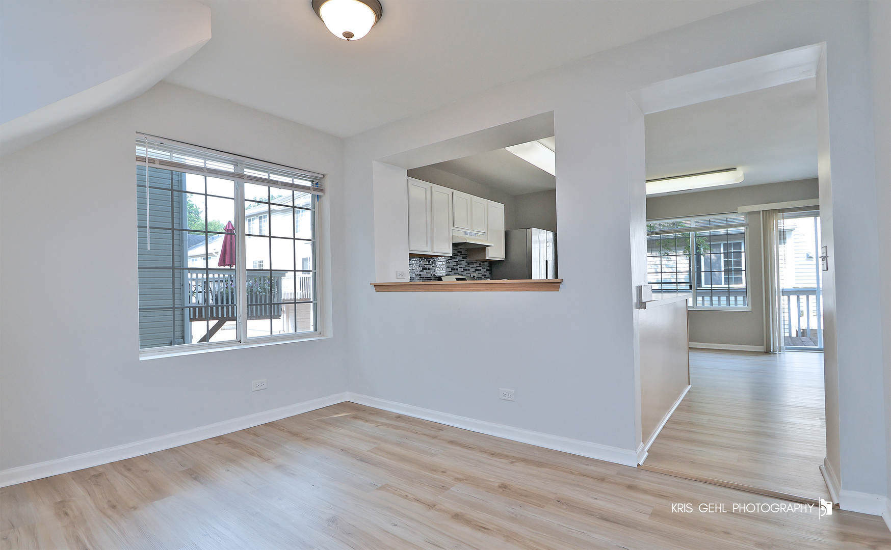 321 West Whispering Oaks Lane, Unit 321 Round Lake, IL 60073 - Photo 5 of 15 an empty room with wooden floor and windows