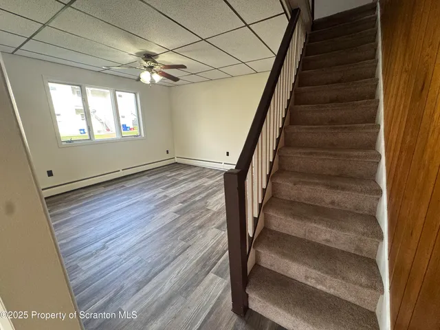 a view of staircase with wooden floor and white walls