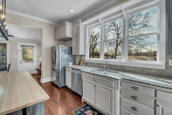 a kitchen with stainless steel appliances granite countertop a stove a sink and a refrigerator