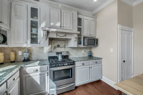 a kitchen with stainless steel appliances granite countertop a stove a microwave and cabinets