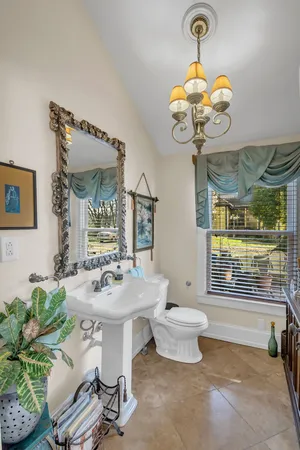a dining room with wooden floor a chandelier a wooden table and chairs