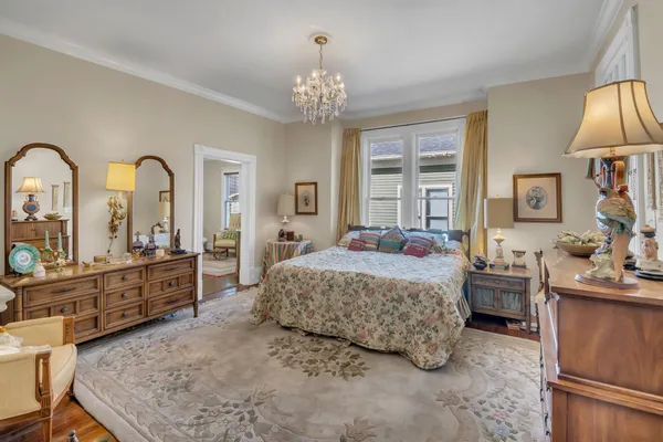 a spacious bedroom with a large bed and a chandelier