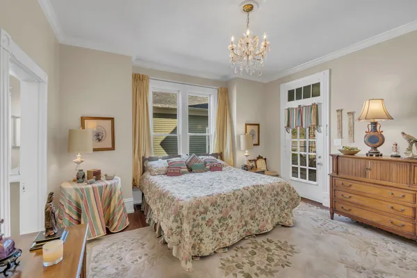 a bedroom with a bed and dresser with mirror