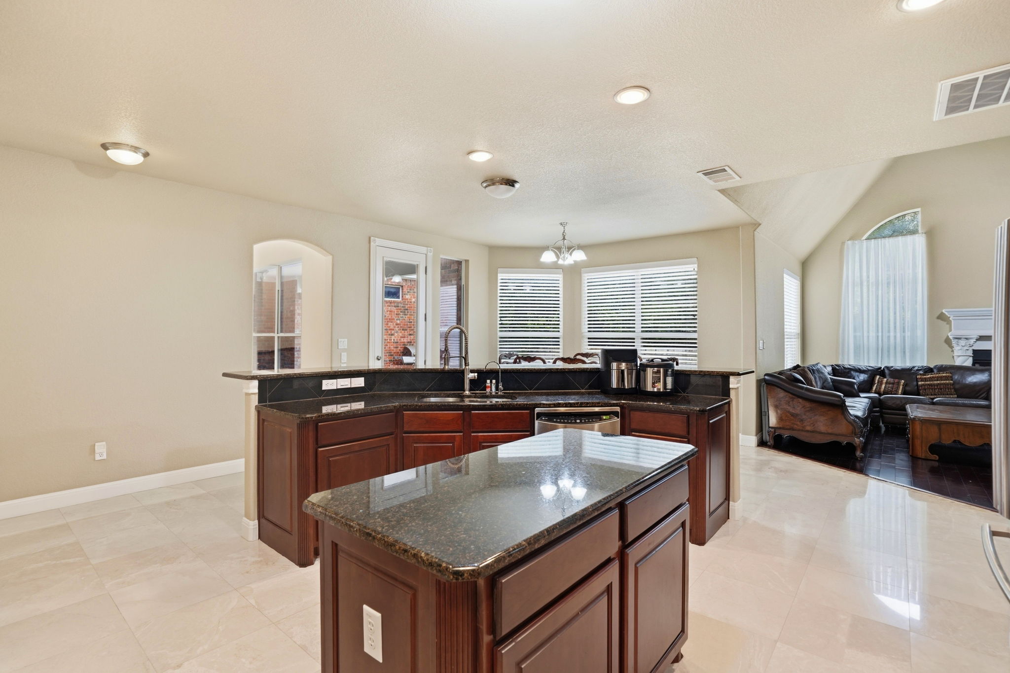 222 Vailco Lane Austin, TX 78738 - Photo 17 of 39 Kitchen island featuring a dark granite countertop and rich wood cabinetry