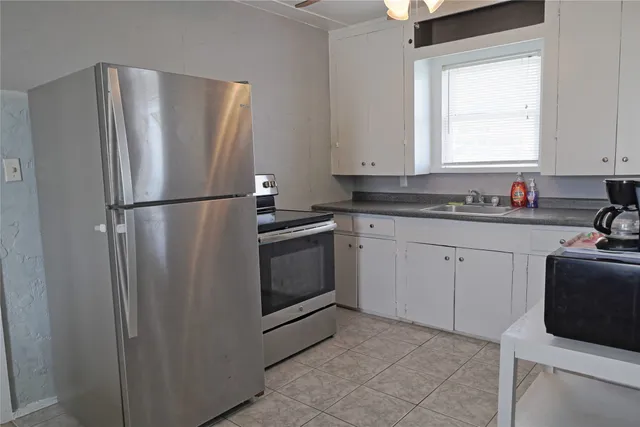 a white refrigerator freezer sitting inside of a kitchen with stainless steel appliances granite countertop cabinets and a refrigerator