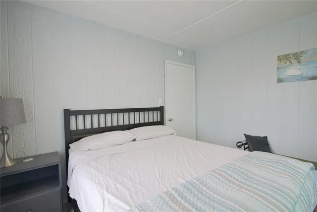 a large bed sitting in a bedroom next to a lamp