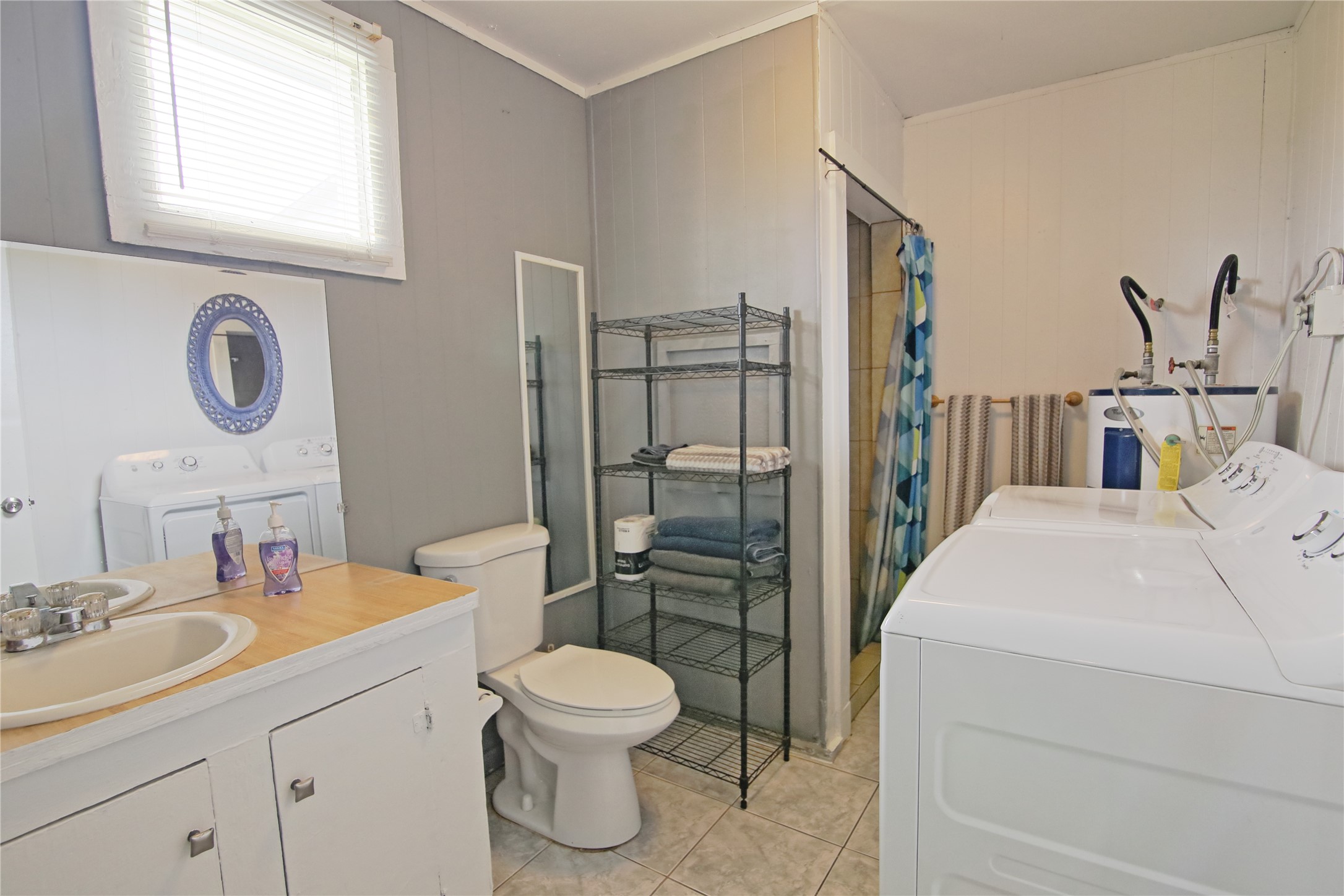 419 Murex Street Surfside Beach, TX 77541 - Photo 17 of 17 a bathroom with a toilet sink a mirror and shower
