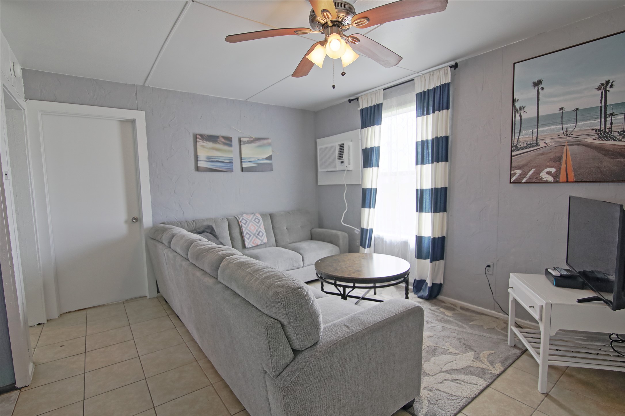 419 Murex Street Surfside Beach, TX 77541 - Photo 5 of 17 a living room with furniture and a dining table with projector