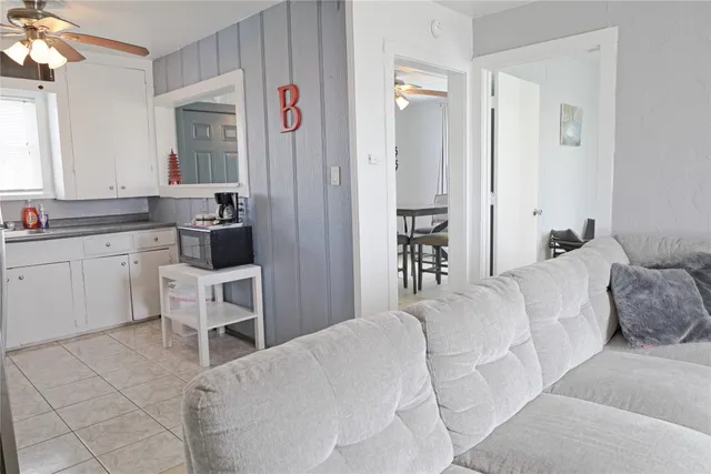 a living room with a couch and a view of kitchen