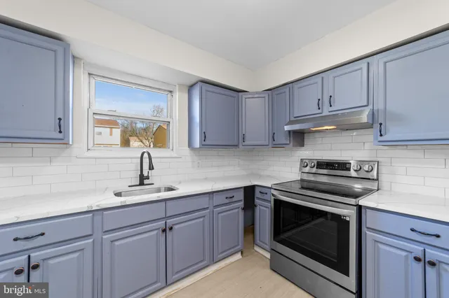 a kitchen with cabinets appliances a sink and a window