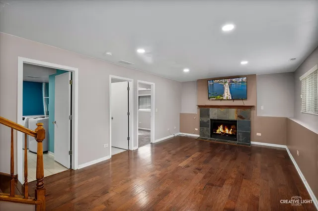 an empty room with wooden floor a fireplace and a window
