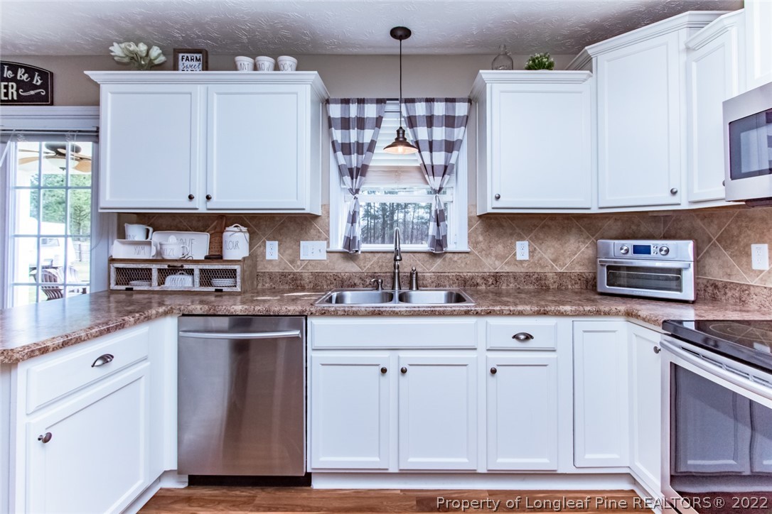 471 United Road Raeford, NC 28376 - Photo 8 of 31 a kitchen with white cabinets and sink