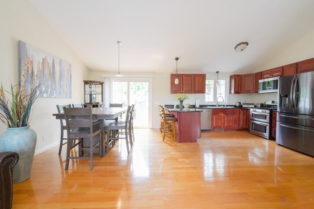 408 Sunderland Road Worcester, MA 01604 - Photo 5 of 24 a kitchen with stainless steel appliances granite countertop a stove top oven a sink a dining table and chairs with wooden floor