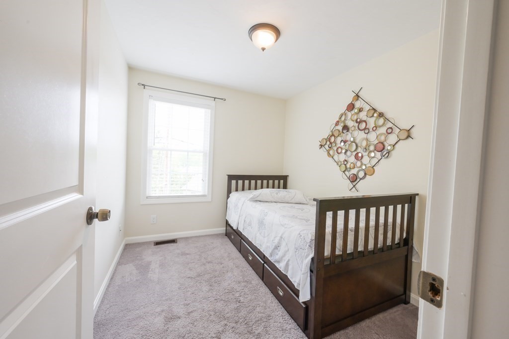408 Sunderland Road Worcester, MA 01604 - Photo 10 of 24 a bed sitting in a bedroom next to a window