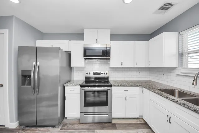 a kitchen with cabinets stainless steel appliances and window