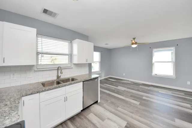 a kitchen with granite countertop a sink cabinets and window