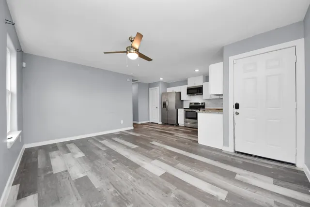 a view of a kitchen with refrigerator and white cabinets