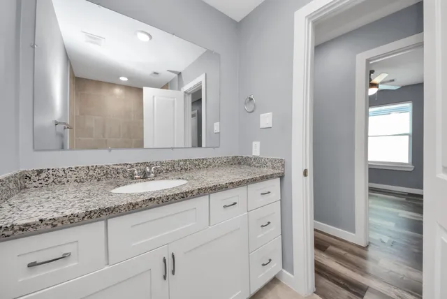 a bathroom with a granite countertop sink and mirror