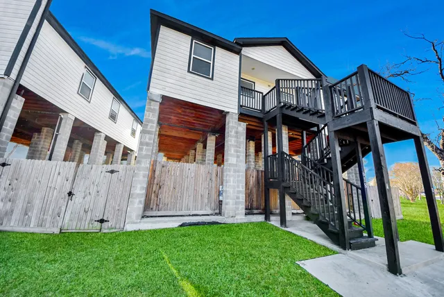 a view of a big house with a big yard and large trees