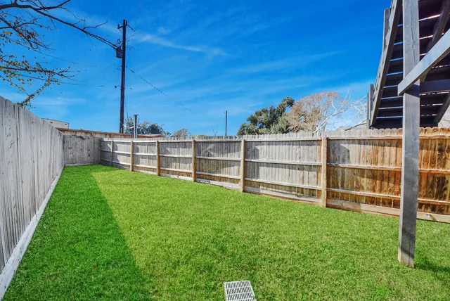 a view of backyard with wooden fence